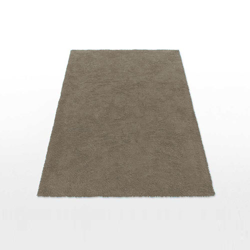 Unique Muschio and Giada rug with black Nero backing a white background.