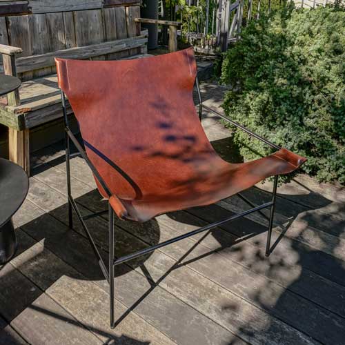 Outdoor chair with weather-resistant brown leather seat.