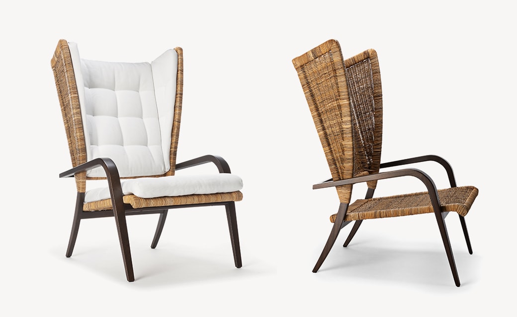Poltrona Bergere lounge chair with a woven rattan frame, dark wooden legs, and plush white cushions