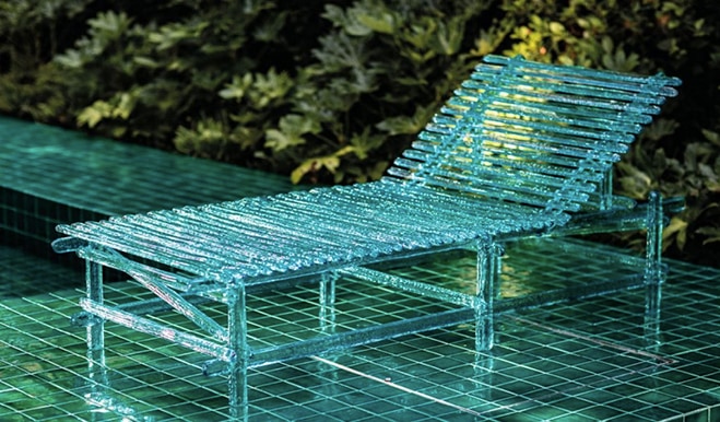 Edra lounge chair with a modern wireframe design in a vibrant turquoise color, set against lush greenery