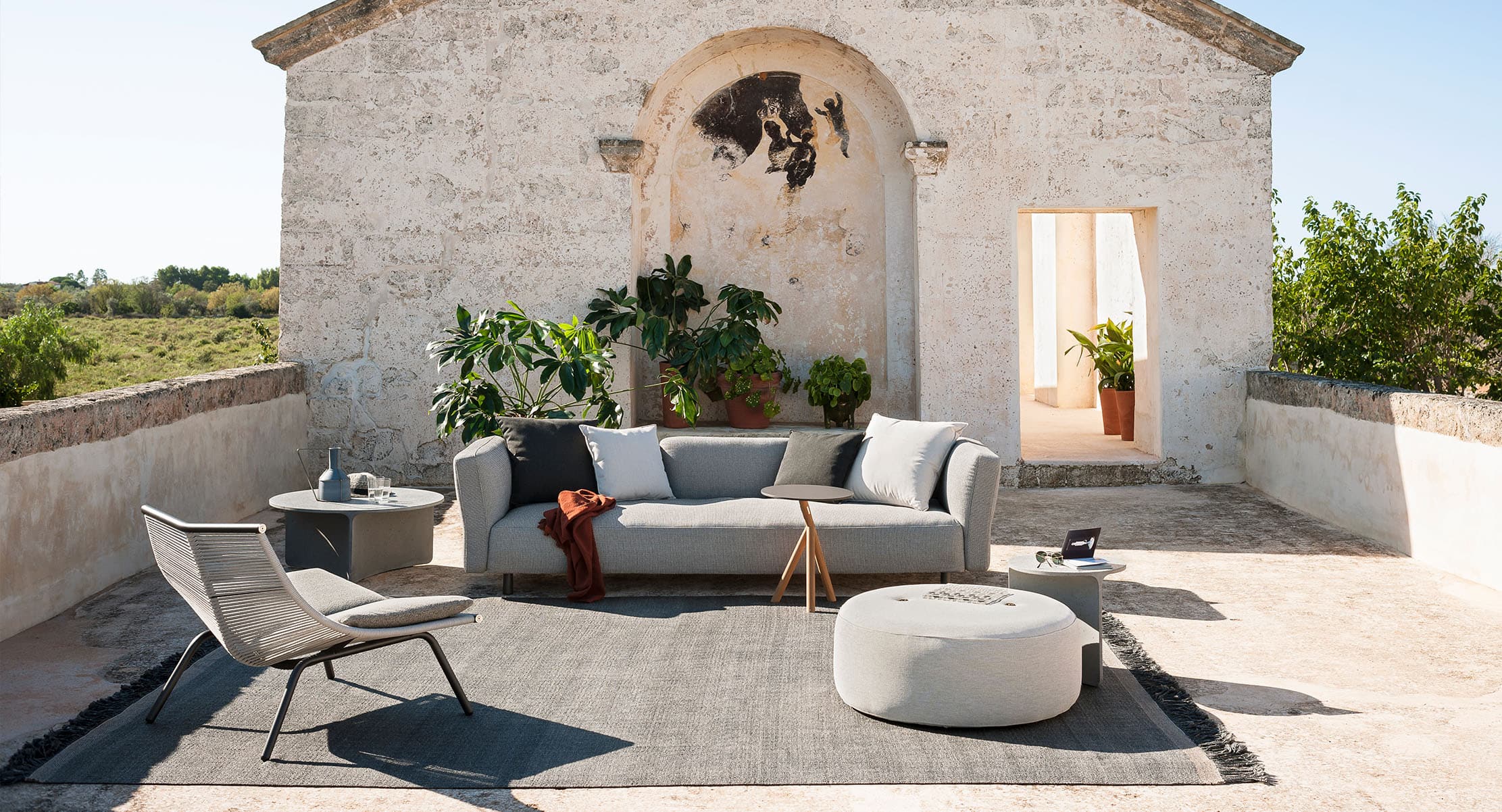 Mamba outdoor sofa set in a rustic courtyard with neutral tones and cozy ambiance