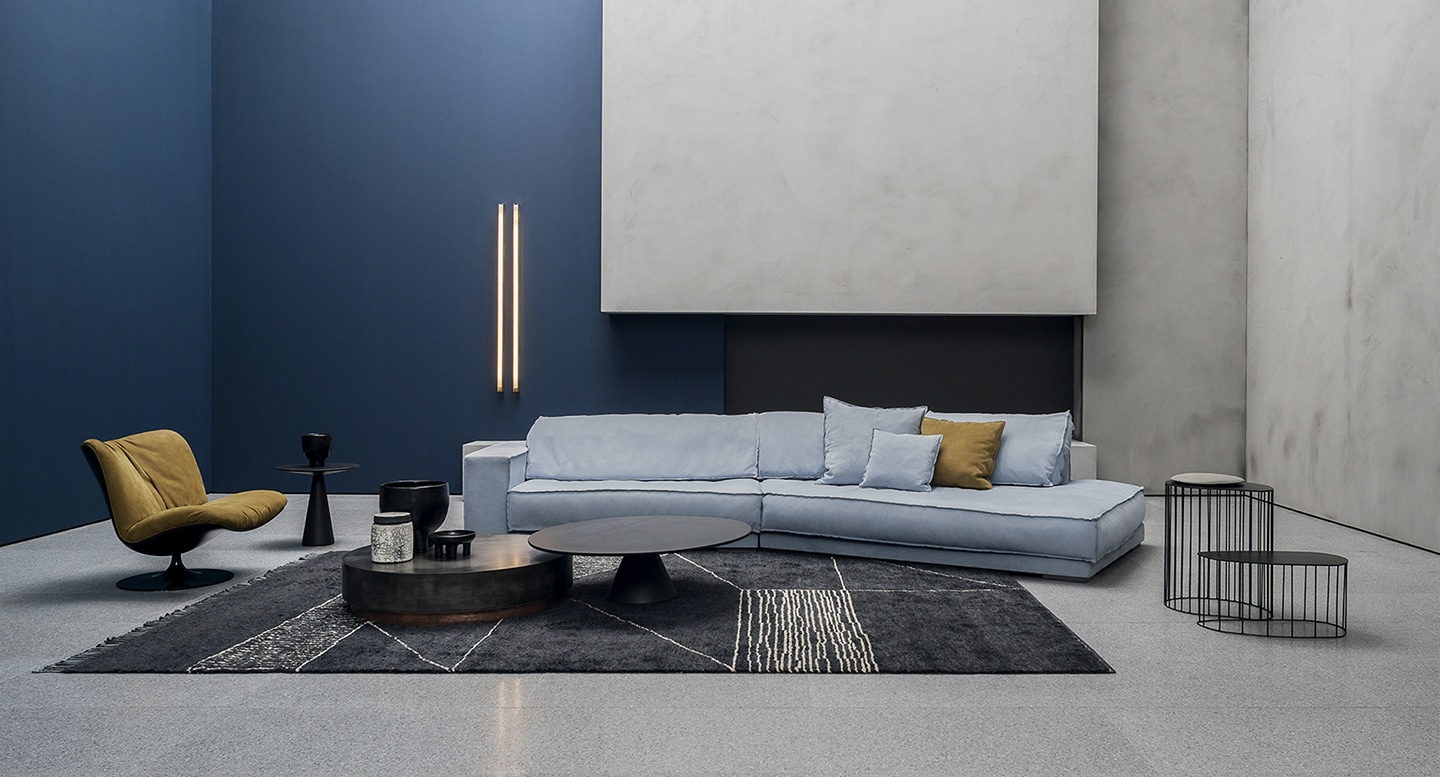 Baxter Budapest sofa in light blue upholstery with a contemporary L-shaped design in a modern living space