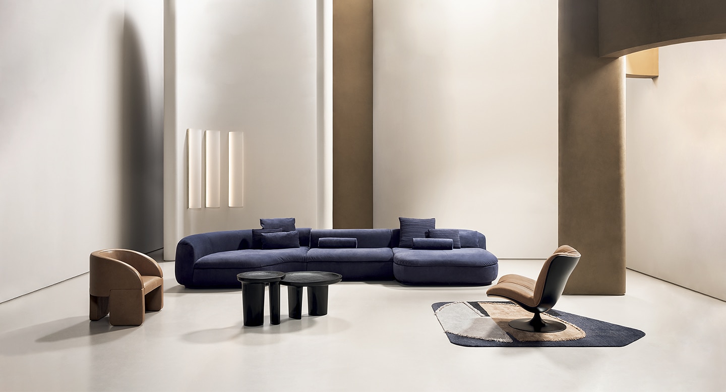 Baxter Piaf sofa in deep blue upholstery with a modular, curvaceous design set in a minimalist modern interior