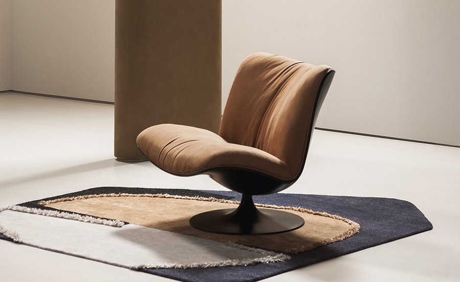 Marilyn lounge chair with a sculptural, curved silhouette and a warm caramel-colored upholstered seat on a black swivel base