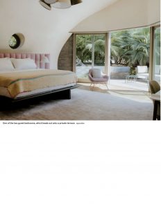 A modern bedroom with a curved ceiling, soft lighting, and a large glass door opening to a lush outdoor view, creating a serene and inviting atmosphere