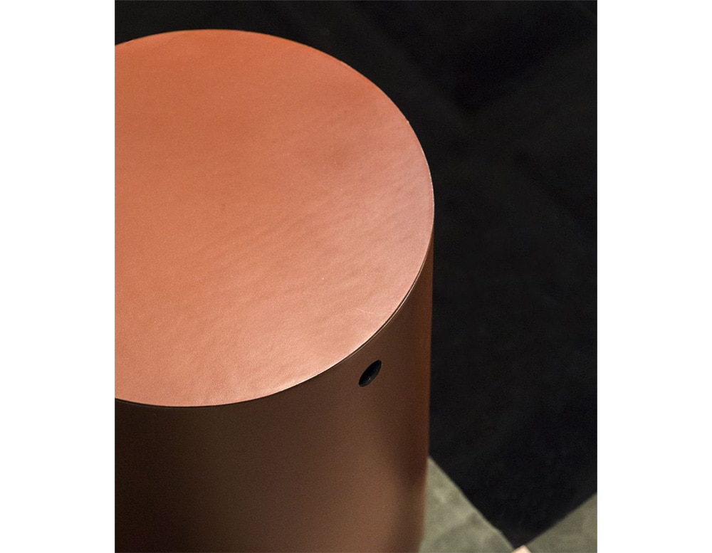 auxiliary circular table made of brass in a brown tone on a black background