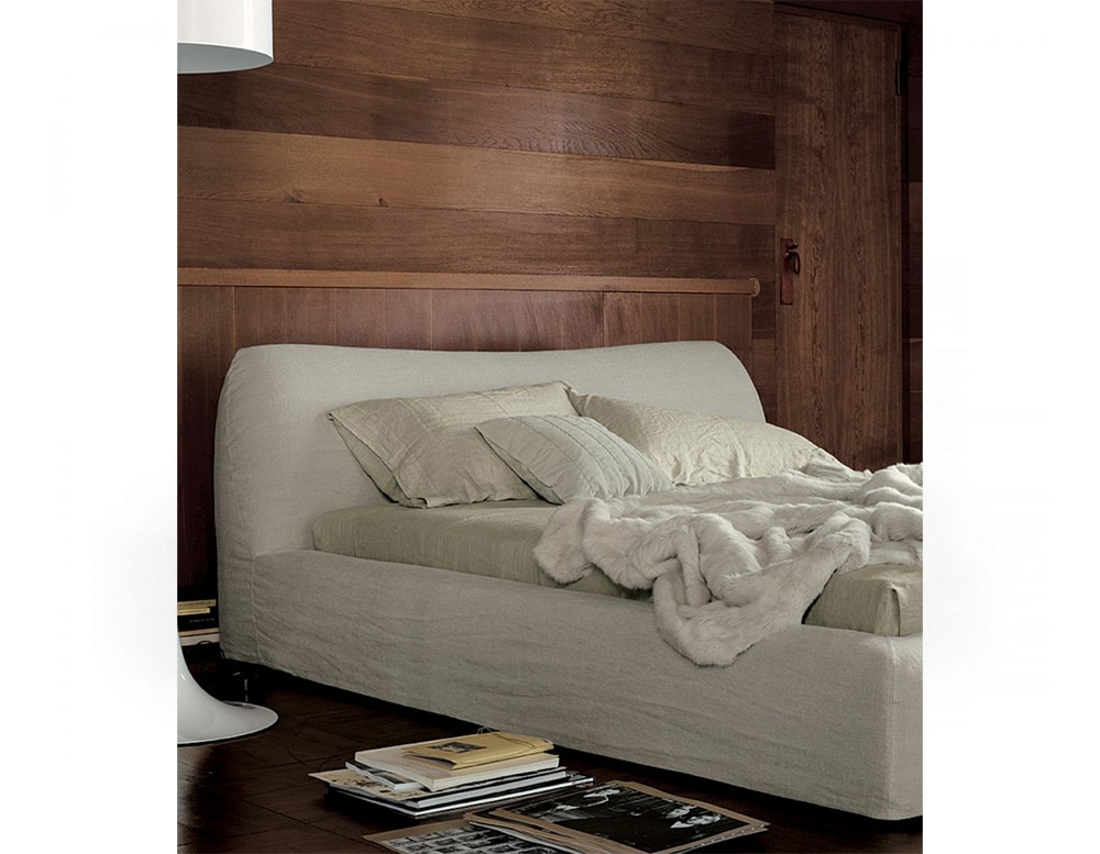 bed upholstered in beige fabric and ash wood base in a living room