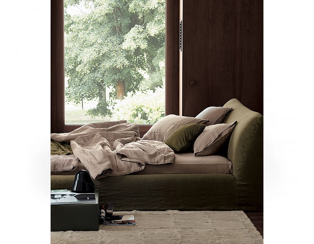 bed upholstered in beige fabric and ash wood base in a living room
