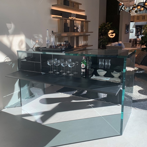 bar made of extra clear glass with black wooden base and several cabinets in a background room