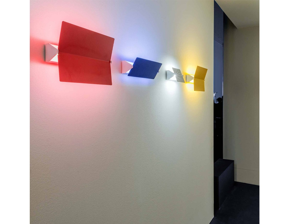line of illuminated diffusers in red, blue and yellow colors on a white wall