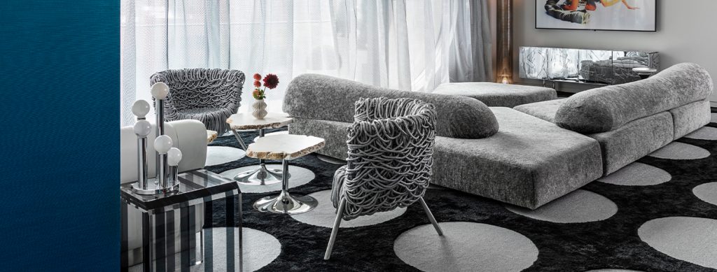 A modern living space with textured seating, sleek marble tables, and geometric-patterned decor, creating a stylish and contemporary ambiance.