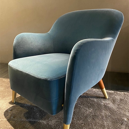 armchair made of wood and blue fabric with textiles in the same tones depending on the armchair