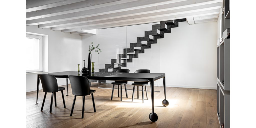 Black extendable table made of aluminum and ash wood in a dinign room