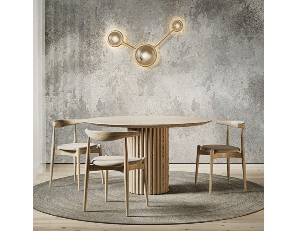 lamp with three connected spheres of a golden tone made with hand-cast metal and white LED lightin a dining room