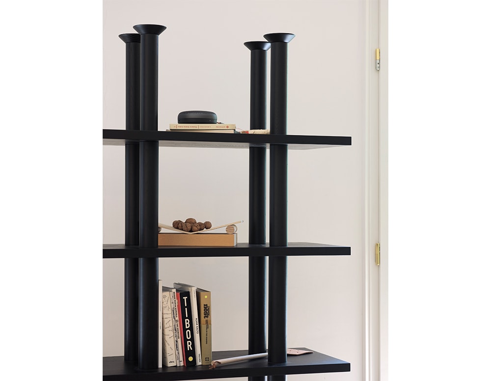 cabinet made of black wood, modifiable in its height levels and base in the shape of tall cylinders
