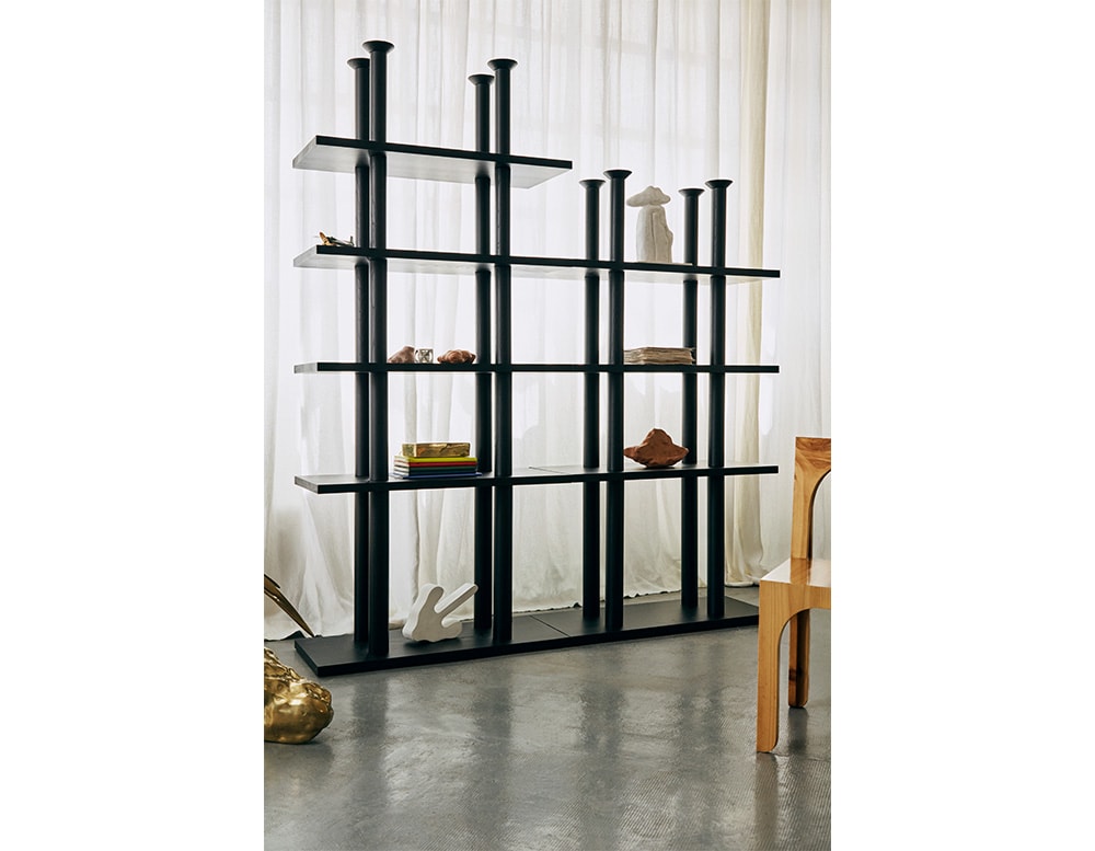 Shelves made of black wood with a shaped base, cylinders and adjustable levels increasing and decreasing.