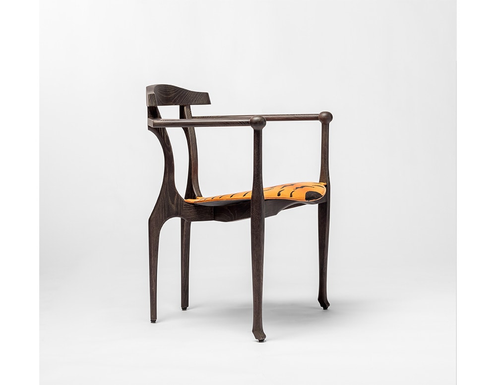 dining chair made from brown wood and upholstered in leather with tiger finishes in a white background