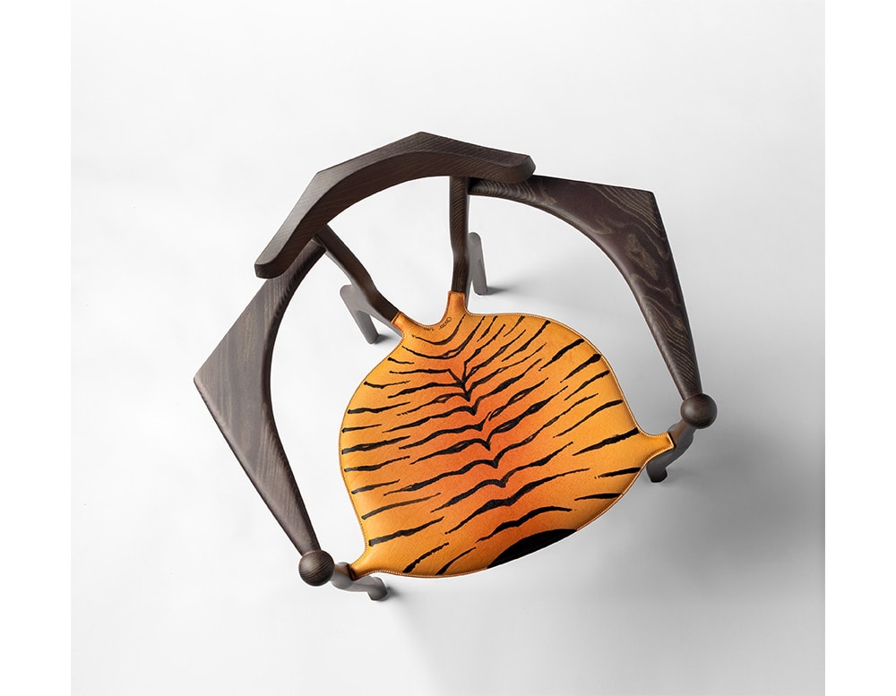 dining chair made of wood upholstered in leather with tiger finishes