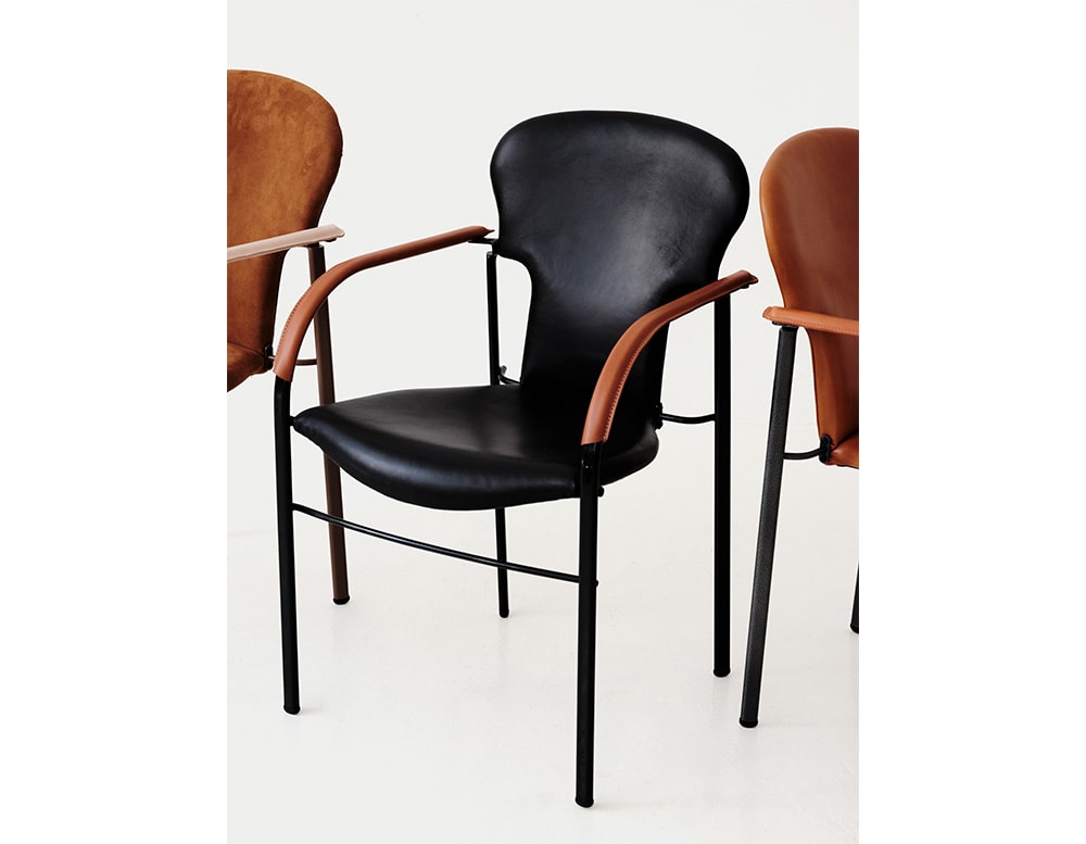 Chair made of metal and upholstered in black leather with brown leather armrests in a white background.