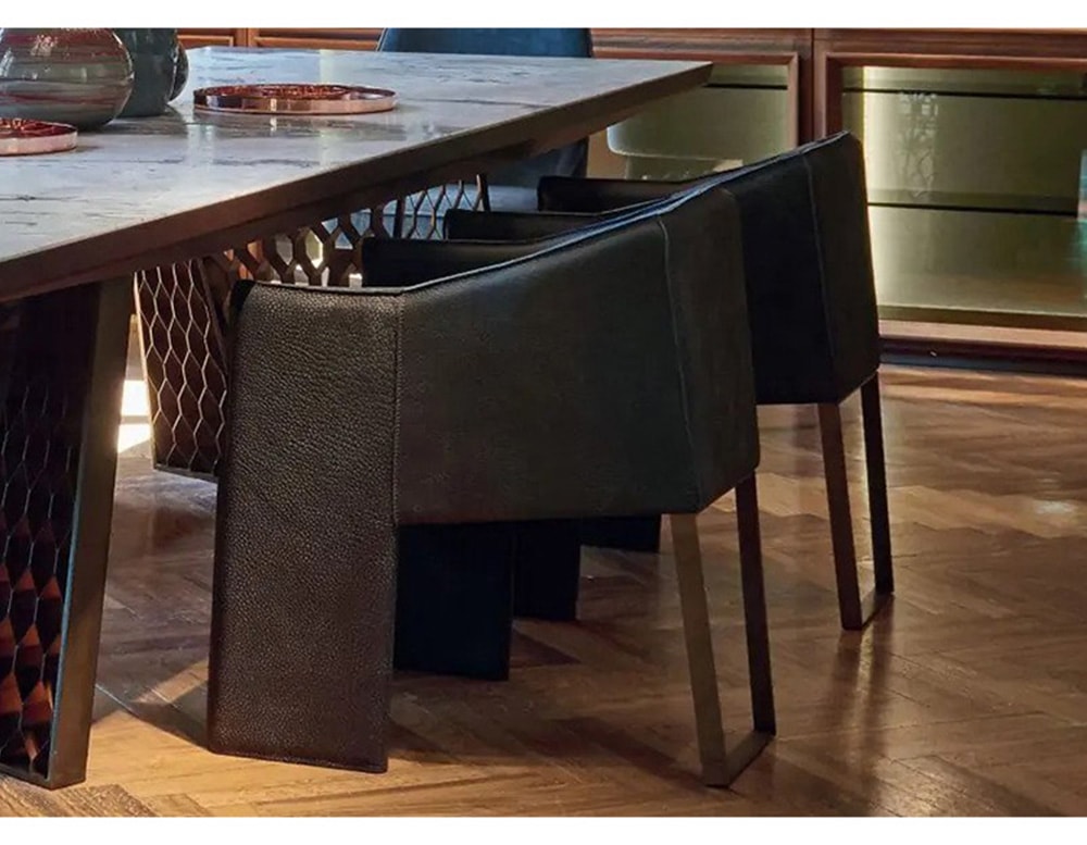 chair made of solid black leather wood and a single back support in brass lacquered steel in a dining room
