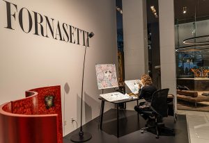 An artist at work during the Fornasetti exhibition, showcasing the meticulous craftsmanship and artistic vision behind the brand’s iconic designs.