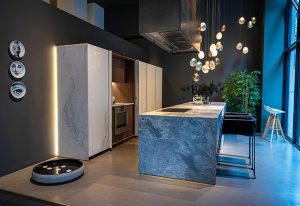 A modern kitchen featuring sleek stone finishes, ambient lighting, and a stylish island that blends functionality with elegance