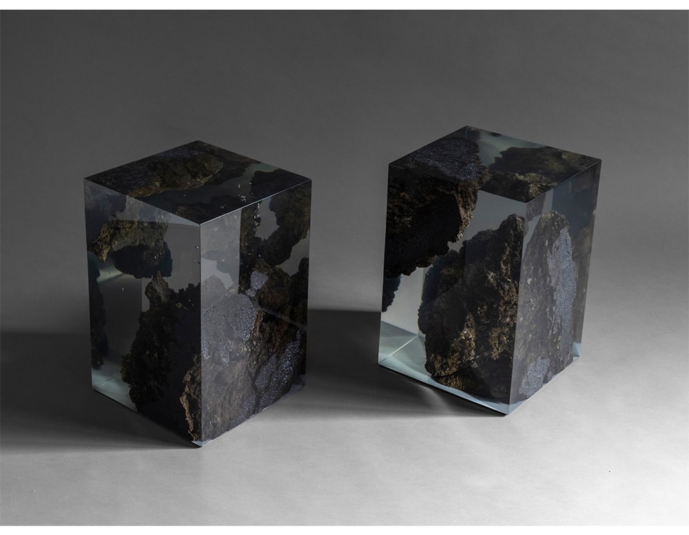 stools made of lava stone and resin with a stone finish inside on a gray background