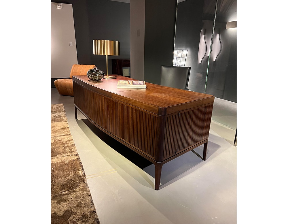 desk made with brown wood with curved design and linear finishes and side drawers