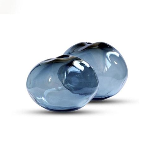 glass sculpture with a round shape and a transparent dark blue color on a white background.