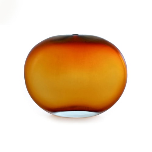 circular glass sculpture with a small hole at the top with a gradient orange color tone