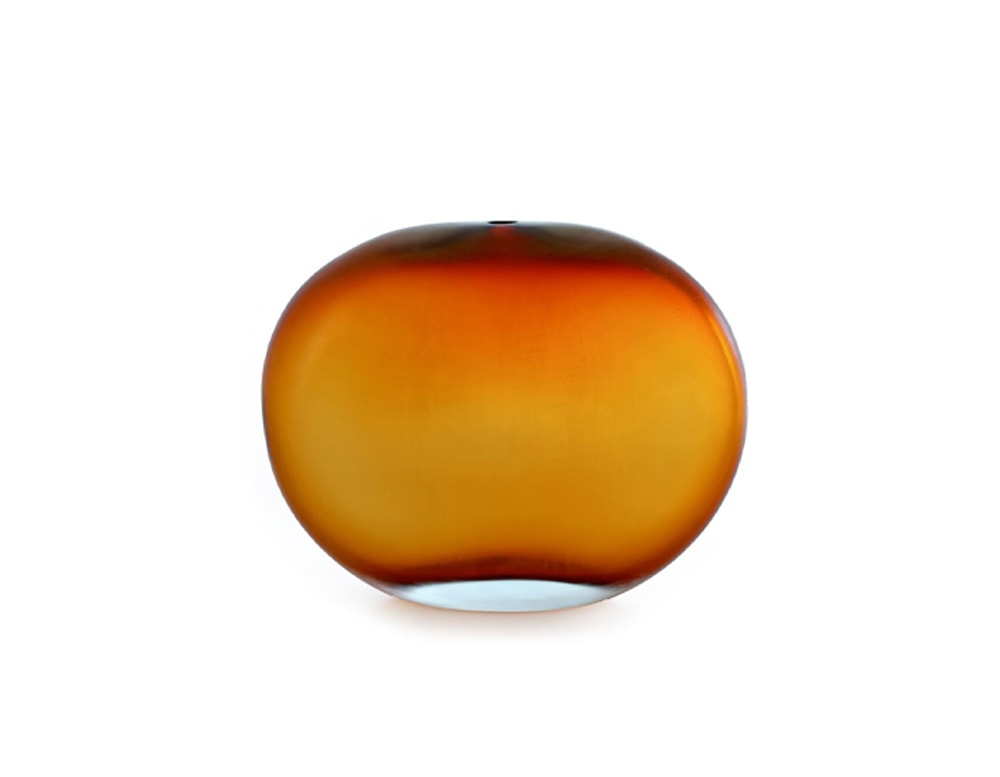 circular glass sculpture with a small hole at the top with a gradient orange color tone in a white background.