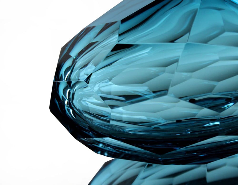 small glass sculpture with bright blue pentagon-shaped design finishes in a white background