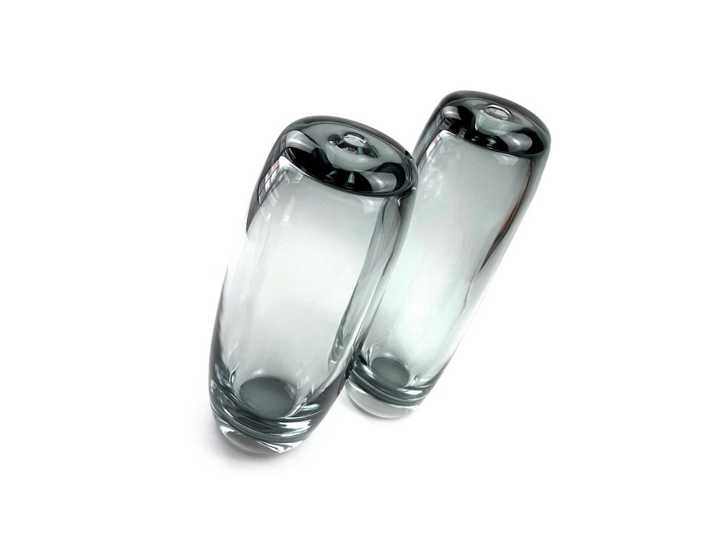 small long cylinders of transparent glass serving as a vase.