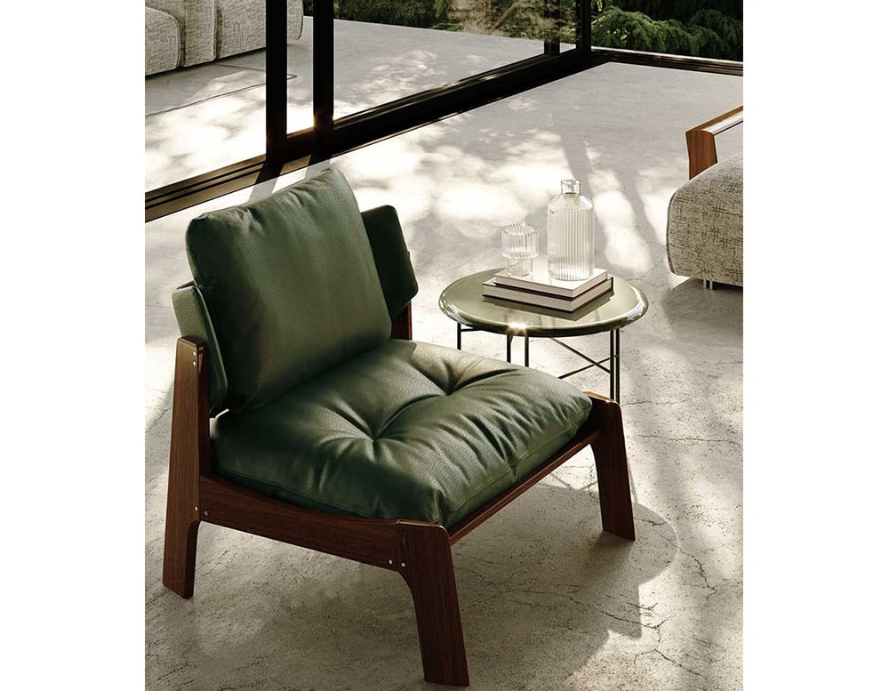 armchair upholstered in green leather and wooden bases.