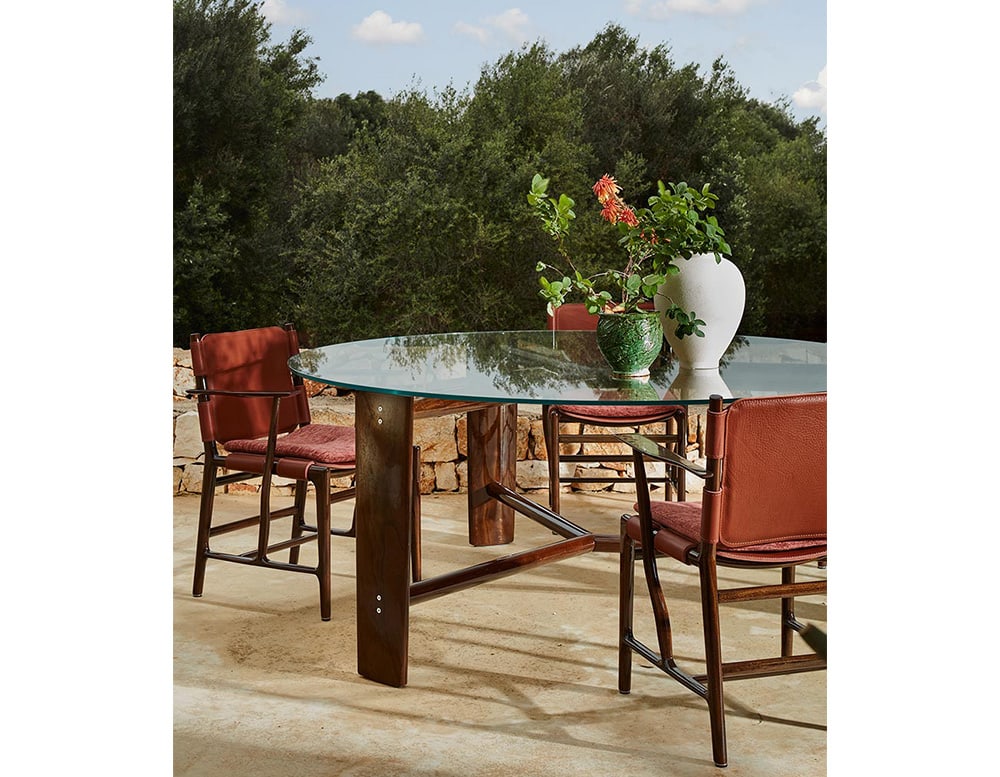 disassembling table with shiny wooden bases and a light and transparent glass top in a living room