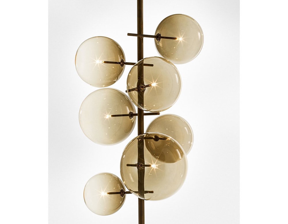 Floor lamp with 7 clear yellow blown glass spheres on a white background