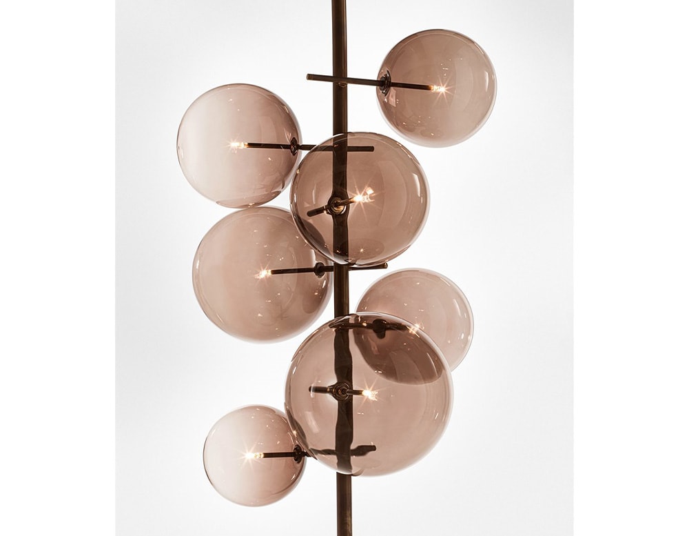 Floor lamp with 7 clear red blown glass spheres on a white background