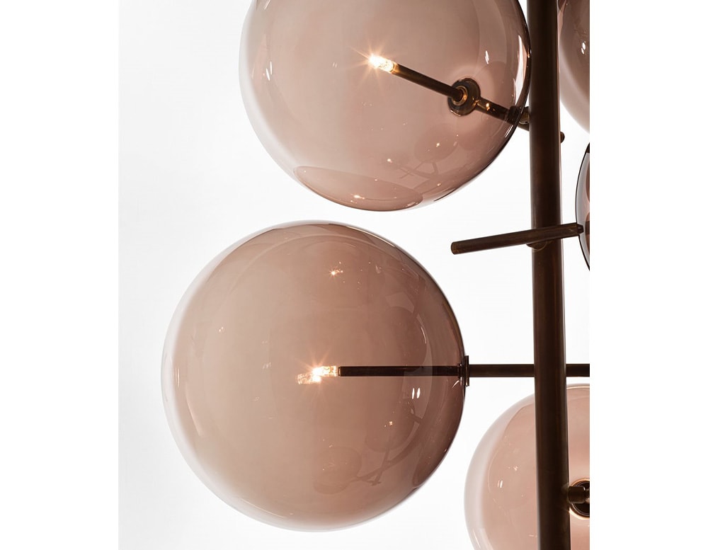 2 of the 7 clear red blown glass spheres of a floor lamp with adjustable LED light on a white background.