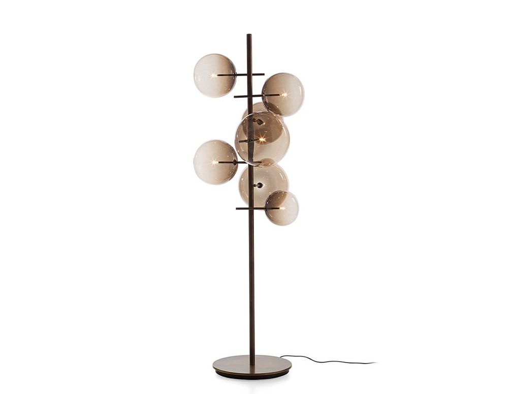 Floor lamp with 7 clear brown blown glass spheres on a white background