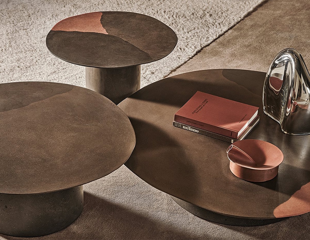 Three brown circular coffee tables in recycled glass in a living room