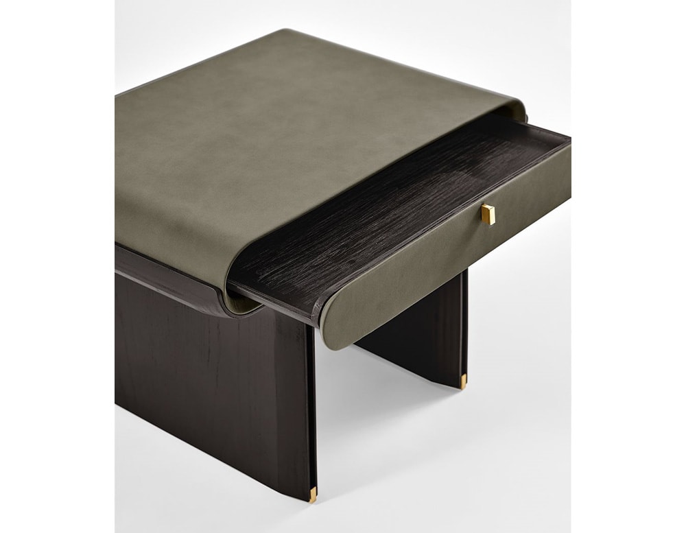 Side view of dark green nightstand with drawer with curved base and dark brown wooden legs.