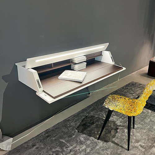 Writing-desk with a brown wood front panel turning into a handy writing table with a built-in desk light and a white matte color lacquered door and top in a wall