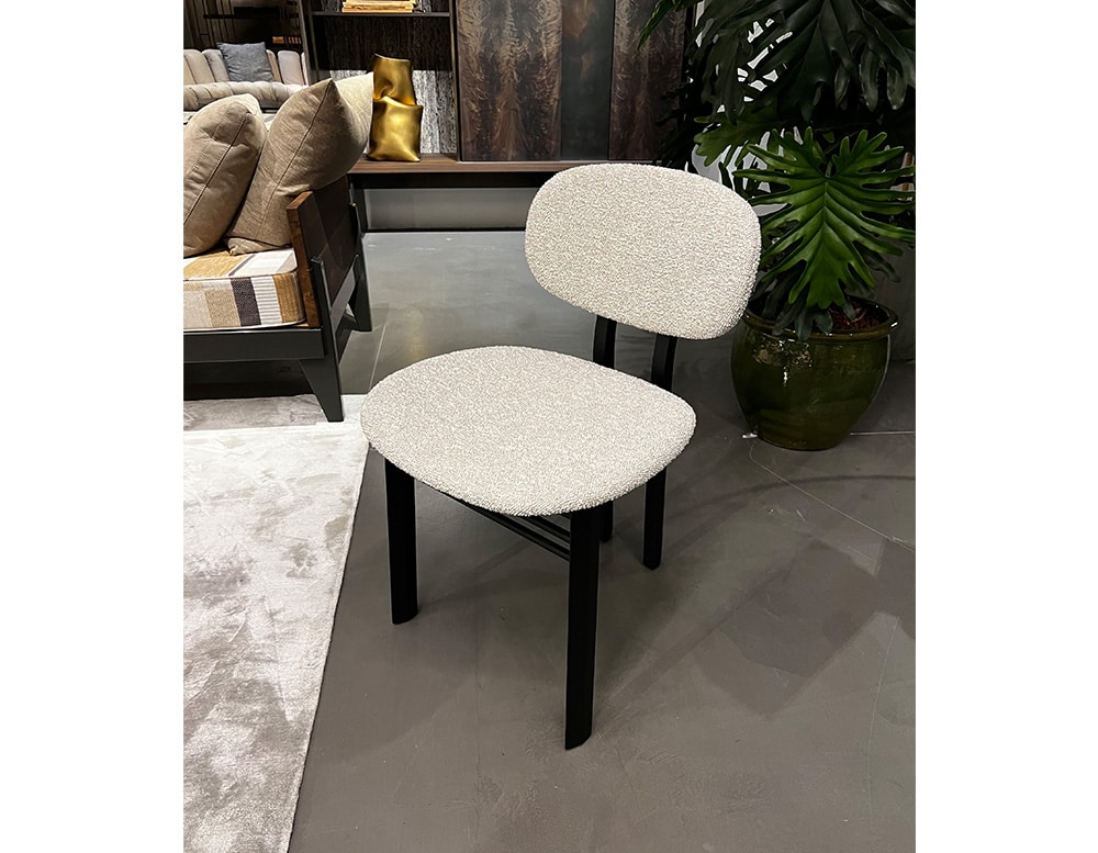 chair upholstered in white fabric and black wooden base