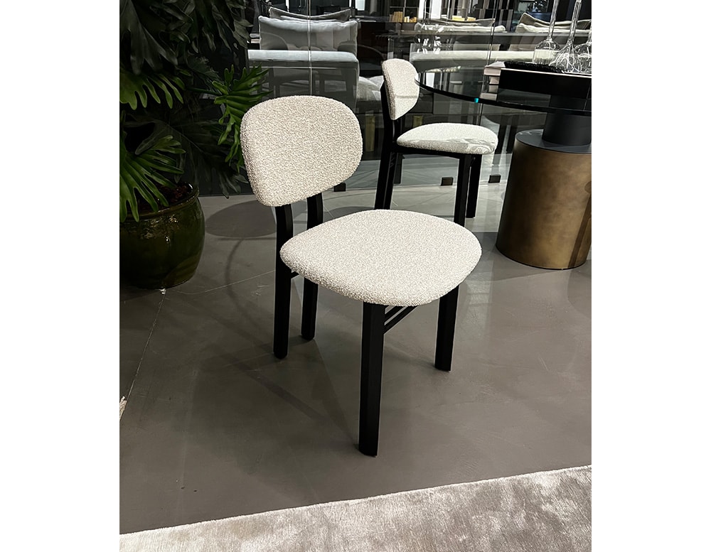 chair made with white fabric and its legs in black wood with shiny finishes.