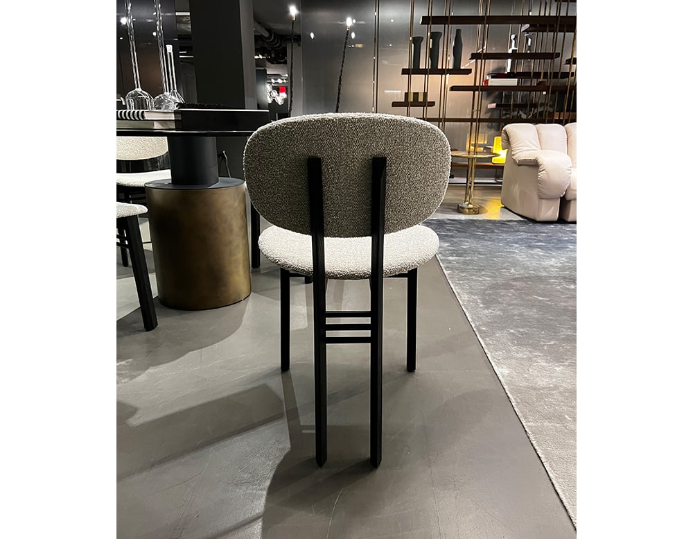 upholstered chair with black wooden base divided into 4 legs