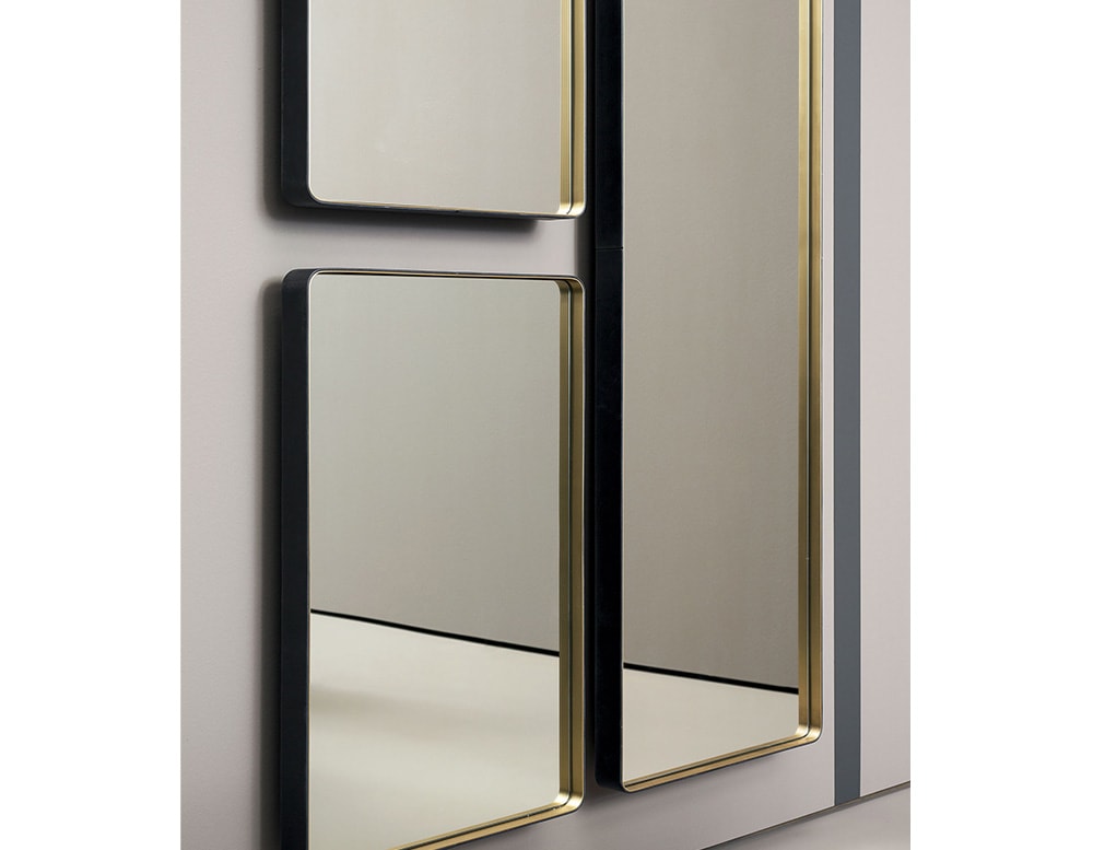 mirror separated into parts with shiny gold edges hanging on a gray wall.