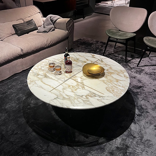 small oval table designed in metal and marble with a different shade of colors such as brown, gold and white.