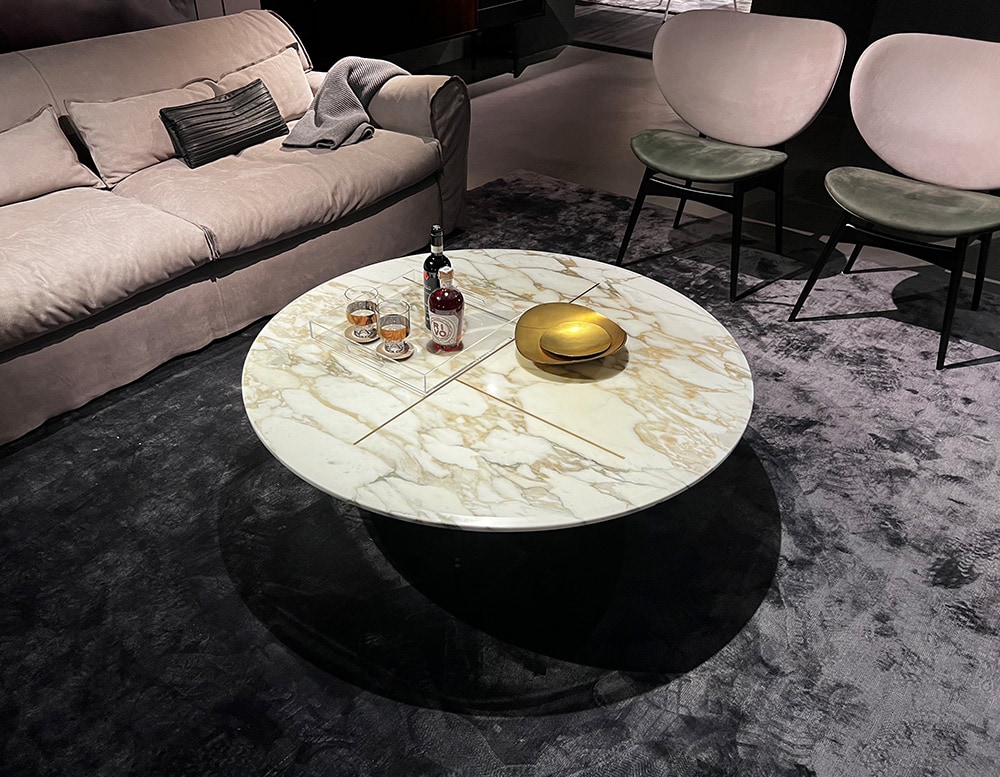 small oval table designed in metal and marble with a different shade of colors such as brown, gold and white.