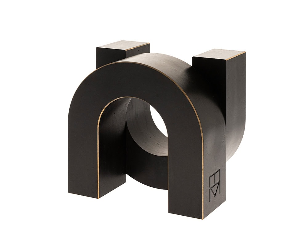 Sculptural accessory in matte black wood with a bold geometric U shape. Its strong architectural lines and smooth surface create a striking decorative piece with a modern and minimalist character.