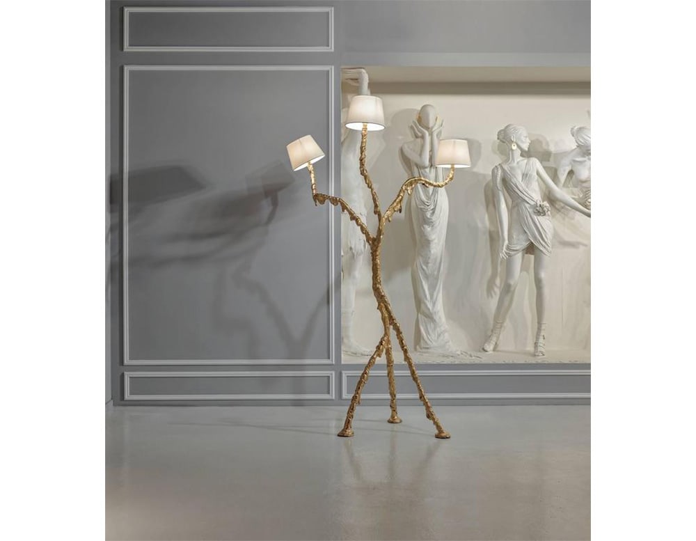 3-part floor lamp made of steel and ballad with gold paint in a living room.